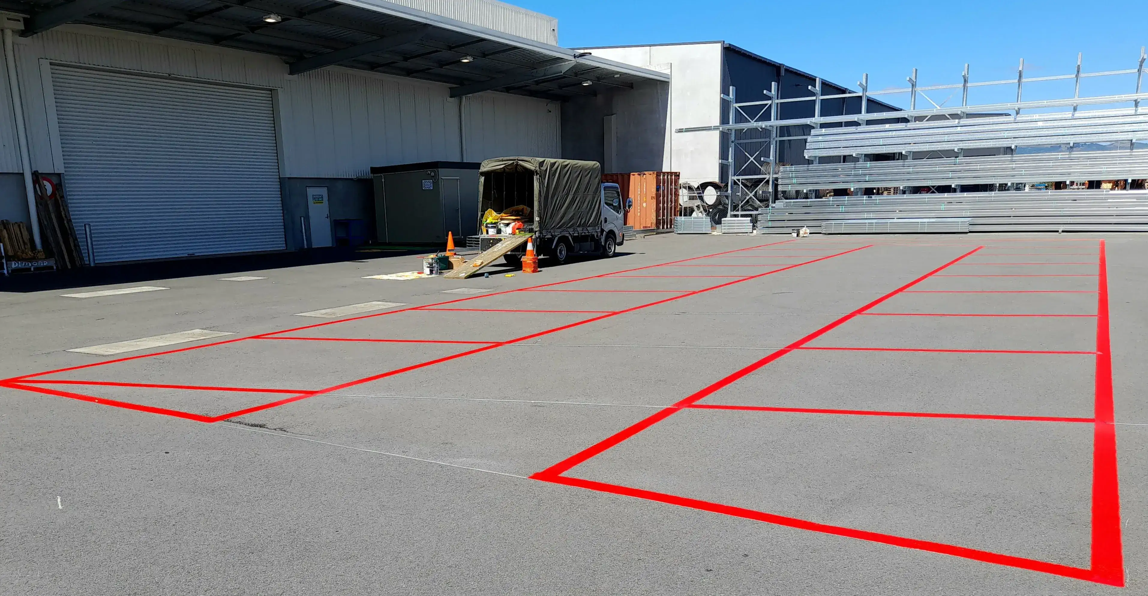 Red exclusion and hazard zone markings installed at an industrial site.