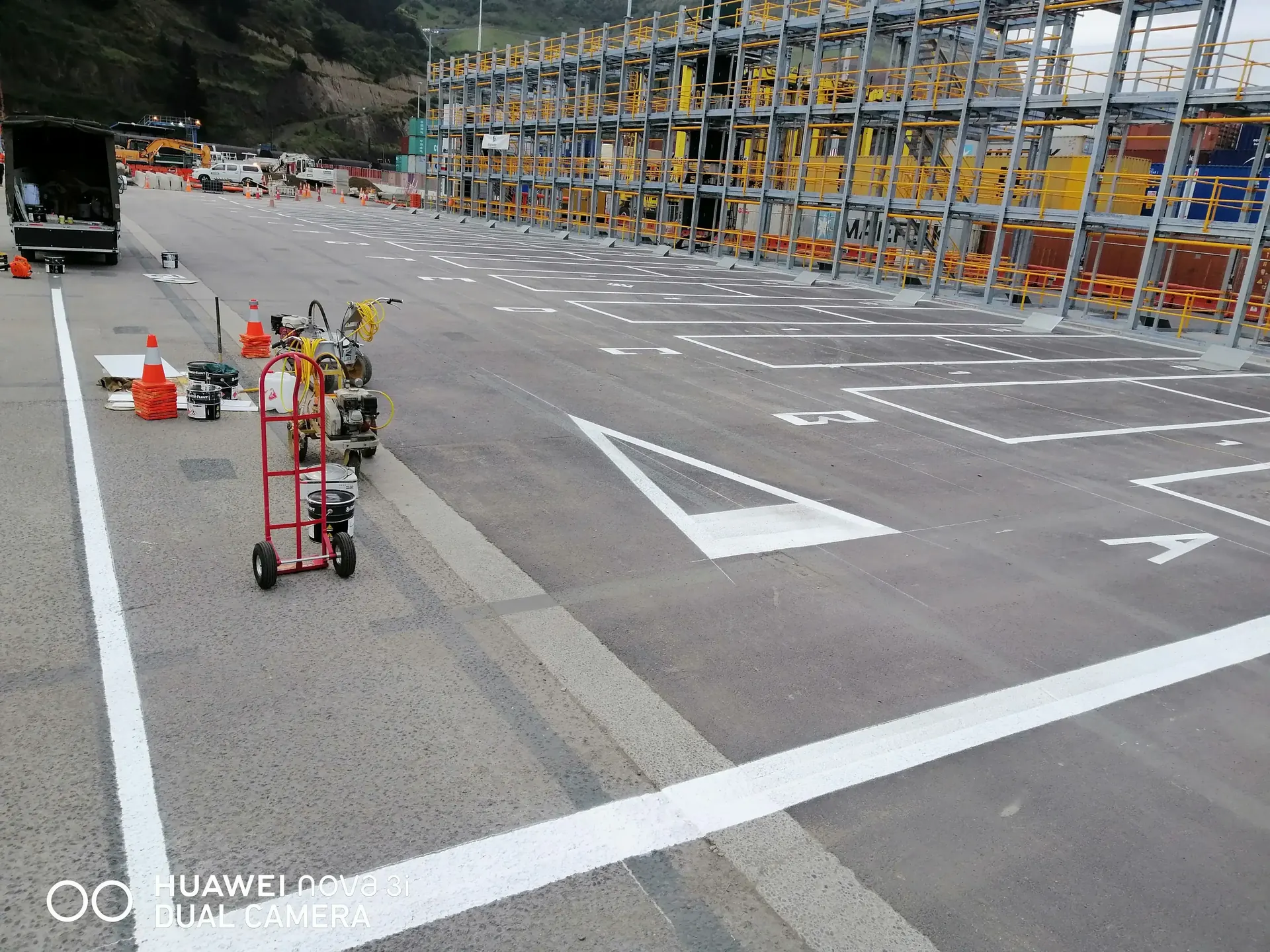 Stencilled bay numbers and letters with safety lines at a logistics hub