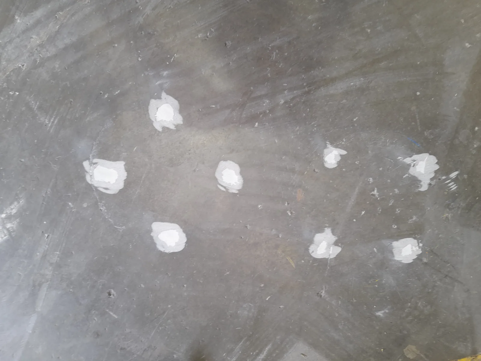 Multiple anchor bolt holes filled flush across warehouse floor after machine base reinstatement — Christchurch