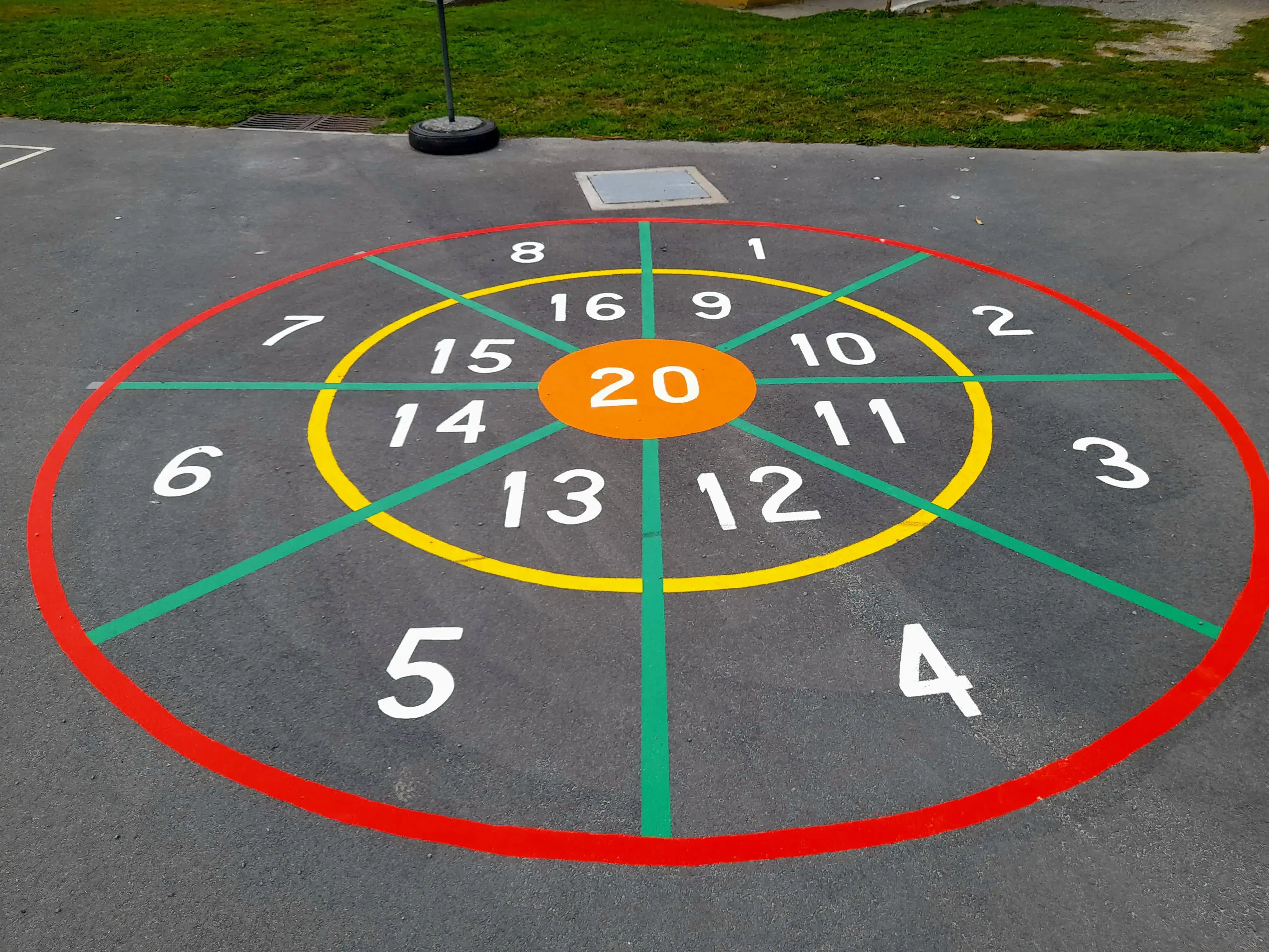 Painted dartboard target game with scoring zones on school playground