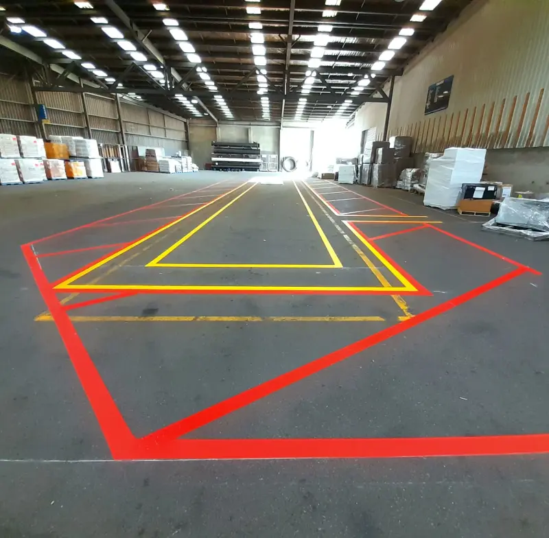 Looking down warehouse aisle with red and yellow safety markings